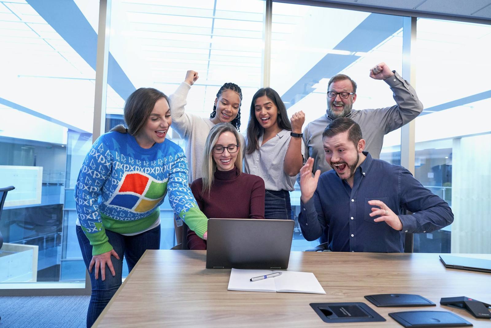 A team celebrating together around a laptop