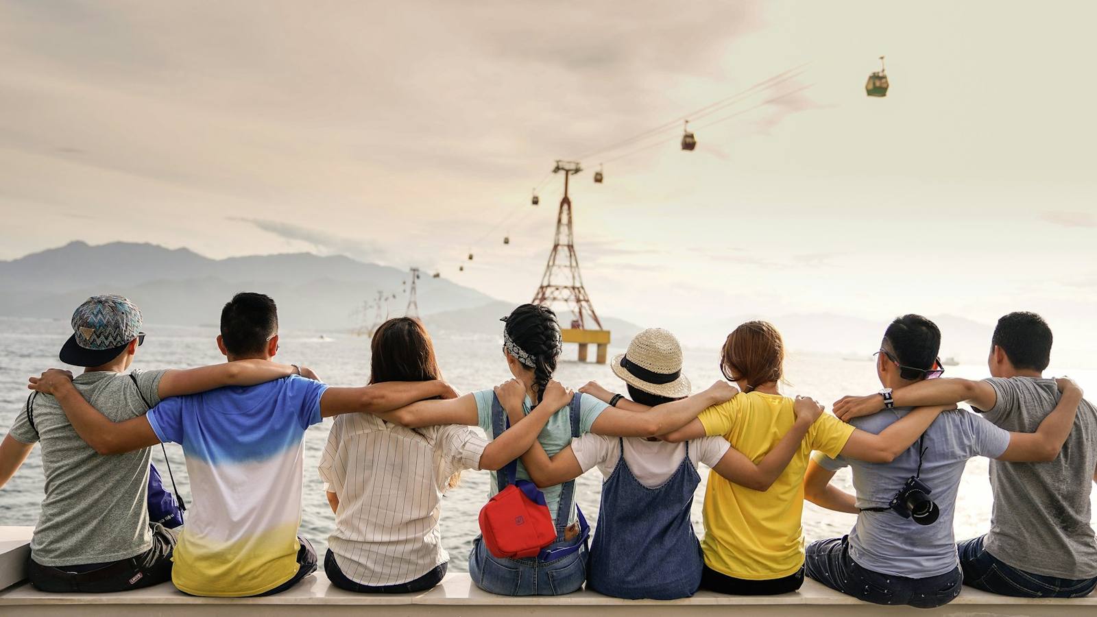 Friends with their arms around each other looking out at the horizon