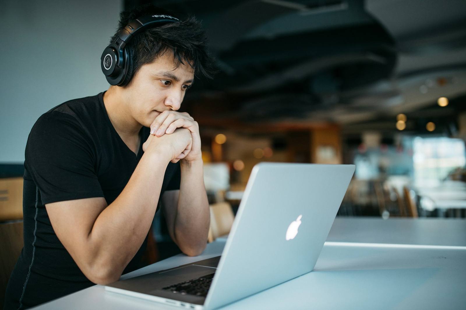 A professional working at a laptop with headphones