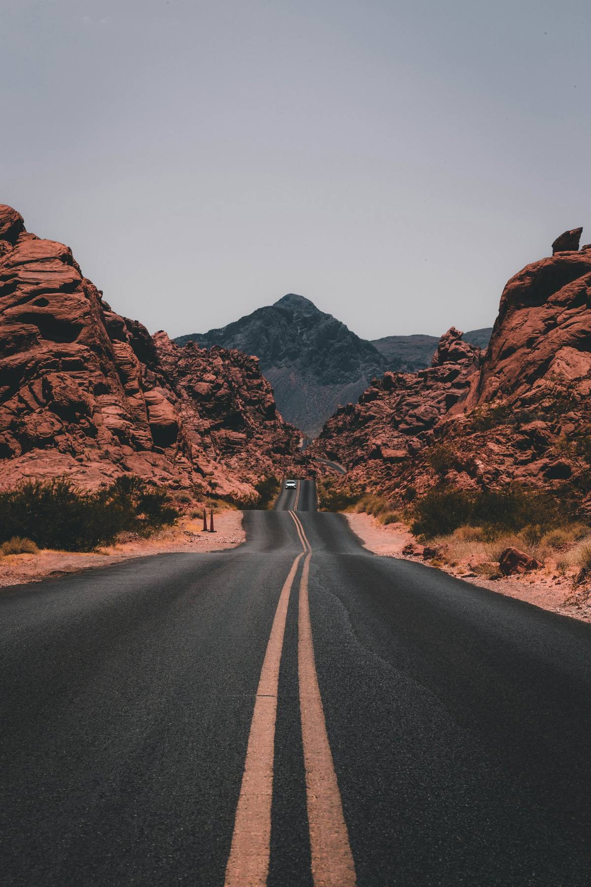 An open road leading toward red rock mountains