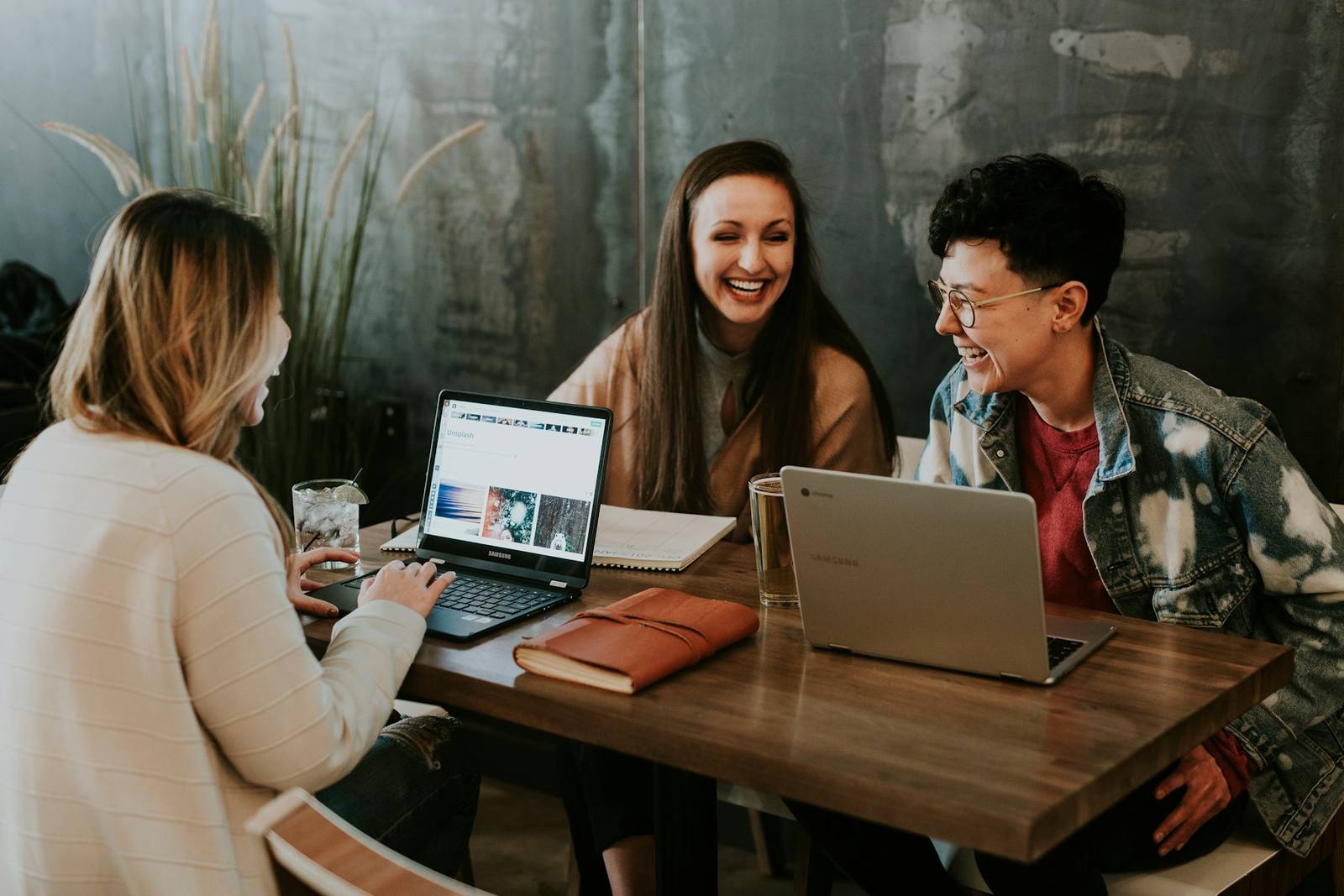 Colleagues laughing together around laptops