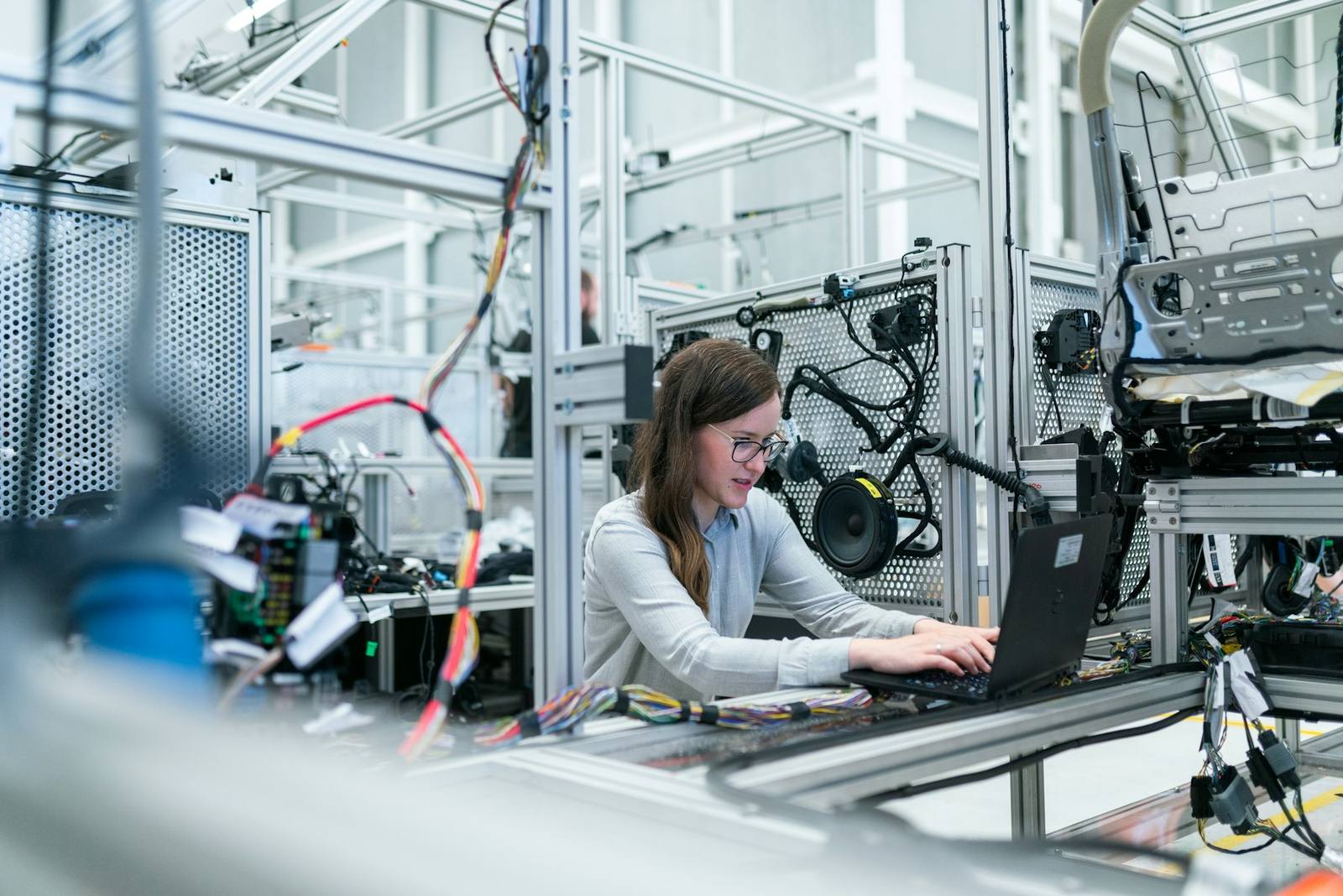 An engineer working at a laptop in a technical lab