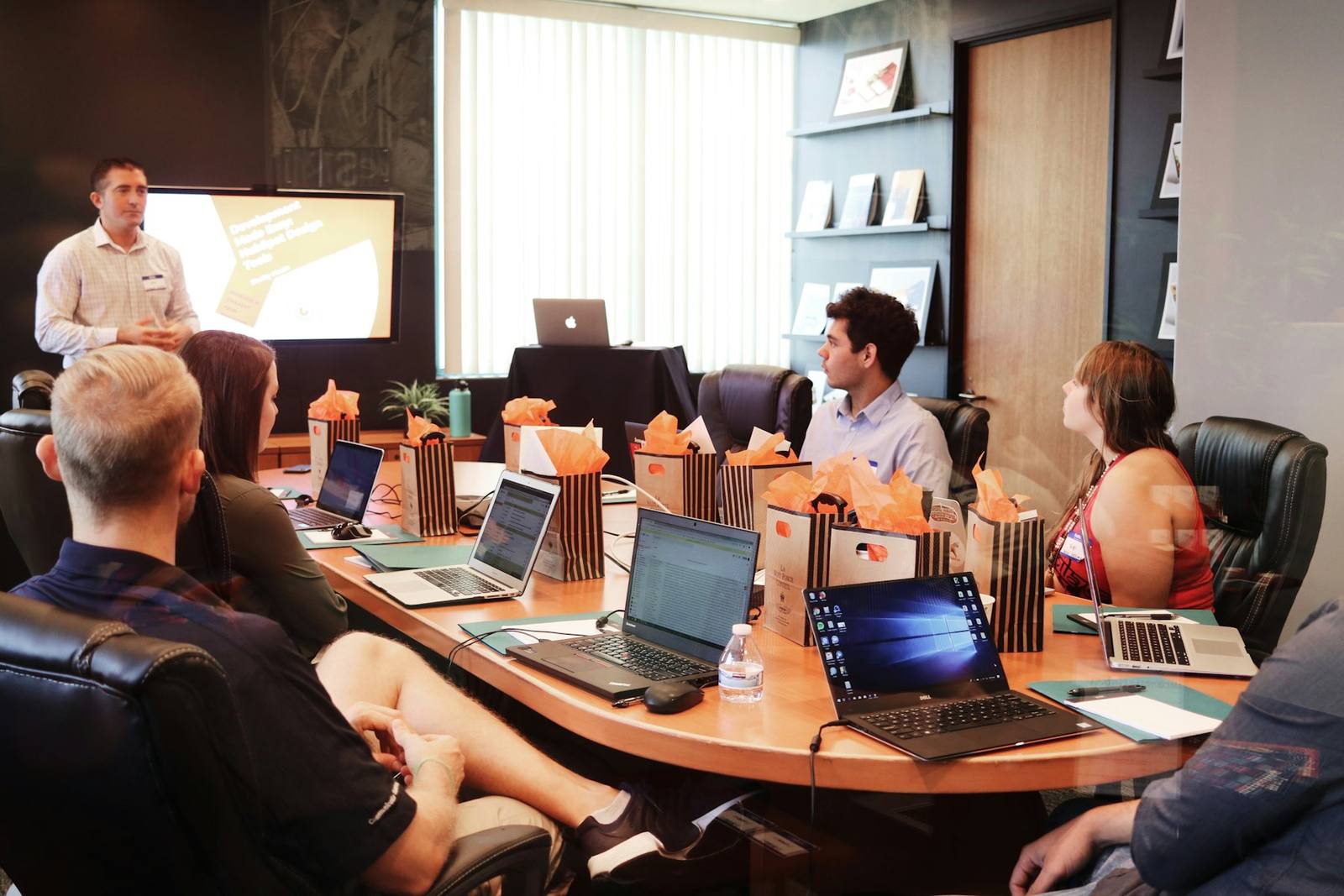 A trainer leading a session around a table of laptops