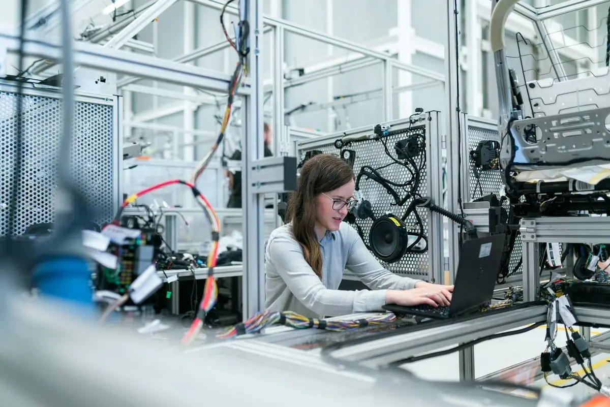 An engineer working at a laptop in a technical lab